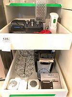 Drawer view showing sharpener, vacuum sealer, grater, timer, three K-Cup carousels, Keurig brewer and box