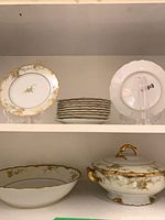 Plates, bowl and covered tureen on shelves showing overall set