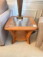 Oak side table between sofas showing glass top and lower shelf