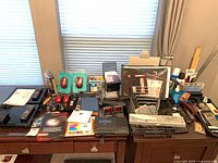 Overall view of electronics, mice, punches, trays and dusters on desk