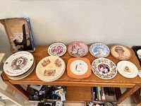 All eleven royal commemorative plates displayed on tabletop