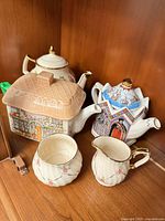 Group shot of three Sadler teapots, creamer and sugar bowl