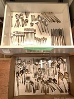 Top drawer view of assorted matching pattern forks, spoons and knives