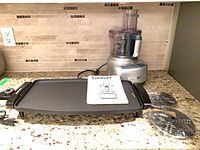 Overall view of griddle, processor, discs and manual on countertop