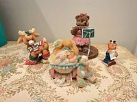 Group shot of four figurines on floral surface