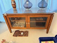 Front view of oak TV stand showing glass doors and glass top