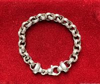 Full bracelet on red background showing link style and clasp