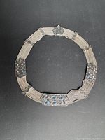 Full view of circular sterling silver multi-strand necklace showing plaques and clasp