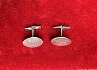 Front view of both cufflinks showing oval monogrammed faces