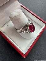 Ring angled showing engraved band and red cabochon