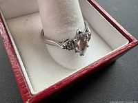 Ring front view in box showing marquise stone and shoulders