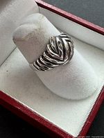 Front angled view of hallmarked sterling silver ridged chevron ring on display mount