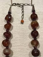 Clasp area showing sterling cone caps, extender chain, orange agate drop