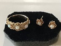 Ring and earrings on foam display, showing stone settings and gold color