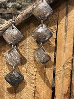 Front view of both earrings showing engraving and four-panel construction