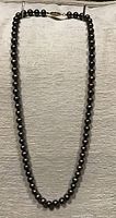 Full view of 18-inch black freshwater pearl strand with clasp