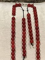 Front view of necklace and two extra bead strands showing bead colour, size, and clasp