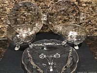 Group view showing two footed bowls and three plates with silver overlay