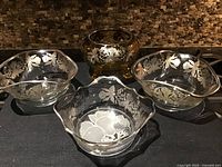 Four glass dishes and bowl with silver overlay floral pattern displayed together