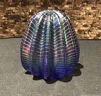 Front view of ribbed iridescent paperweight