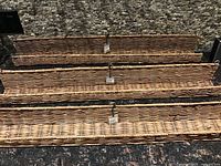 Three matching woven rattan wall ledges arranged side by side showing front view and tags attached.