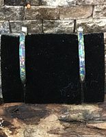 Front view of both silver abalone hoop earrings on display card