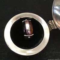 Ring in case showing cherry amber side