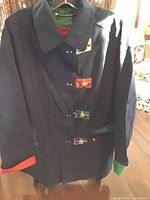 Front view of blue windbreaker showing latch closures and colour-block cuffs