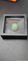 Opal cabochon in display case
