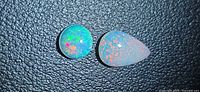 Round and pear opals on textured background showing colour play