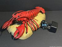 Front angled view of animated lobster plaque with power adapter shown