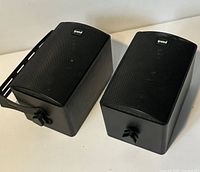Two black Punch speakers side by side with bracket attached, view of tops
