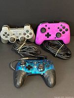 Front view of three wired controllers showing designs and cables