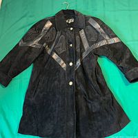 Front view of black leather jacket with appliqué