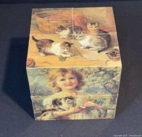 Folded cube showing kitten scene on front and child scene on side