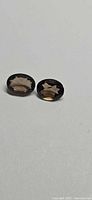 Two oval smoky quartz gemstones side by side
