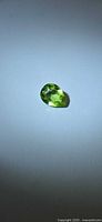 Pear cut green peridot on neutral background