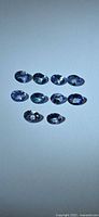 Group of nine oval Tanzanite gems on neutral background