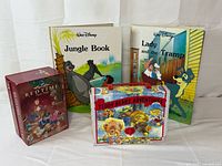 Front view of all items: two Disney hardcovers, Bedtime Fairy Tales box, Teddy Bears' Adventures suitcase set