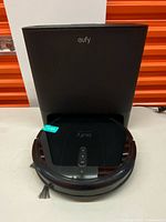 Robot vacuum docked in self-emptying station front view