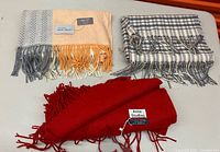 Three scarves laid out showing colours, patterns and fringe