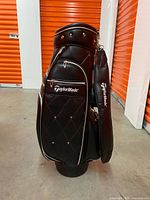 Full front view of black TaylorMade cart bag showing main body and logo