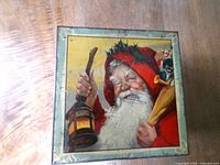 Lid view showing Santa with lantern and toy sack artwork