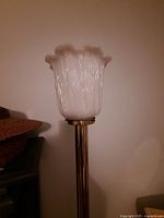 Close-up of ribbed molded plastic shade with scalloped edge showing crack