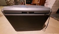 Front view of closed Coleman electric cooler with power cord attached