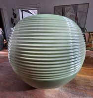 Side view showing ribbed spherical green vase