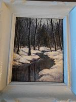 Framed winter landscape painting in white frame