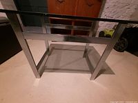 Full view of table showing stainless frame and glass top