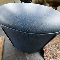 Side view of blue vinyl ottoman