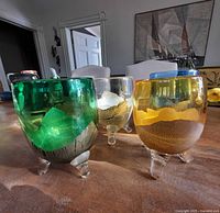 Four colored footed goblets on table